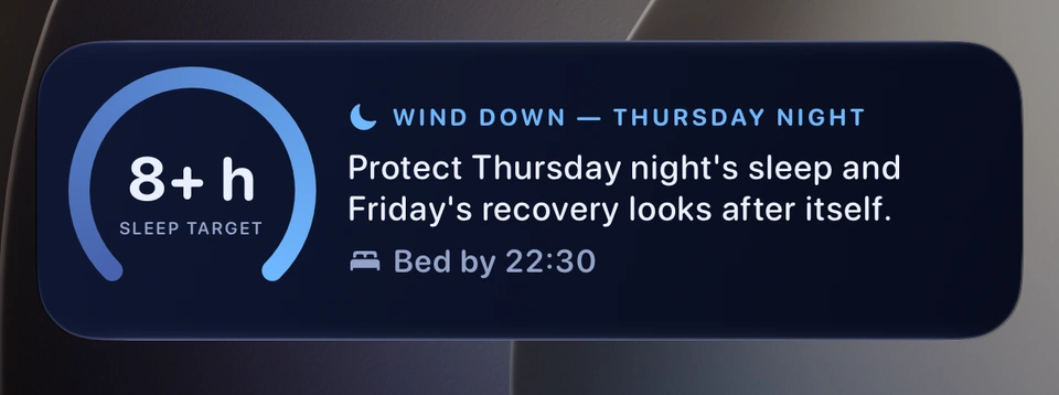 The bedtime wind-down card on the iPhone Lock Screen: a ring reading the sleep target in hours, the heading Wind down with the night's name, a line about protecting that night's sleep so the next day's recovery looks after itself, and Bed by with the time.